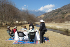 Rockjumpers fågelskådningsgrupp i Bhutan 2020 njuter av en tepaus runt ett popup-bord bredvid en bäck